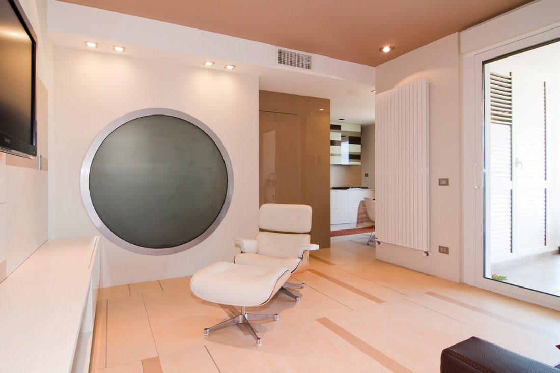 Immagine di un progetto di interior design a Vasto. Si possono vedere il salotto moderno con eames chair, un'ampia vetrata e un grande oblò circolare