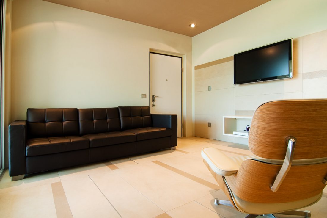 Immagine di un progetto di interior design con dettaglio del salotto con un divano in pelle e una eames chair